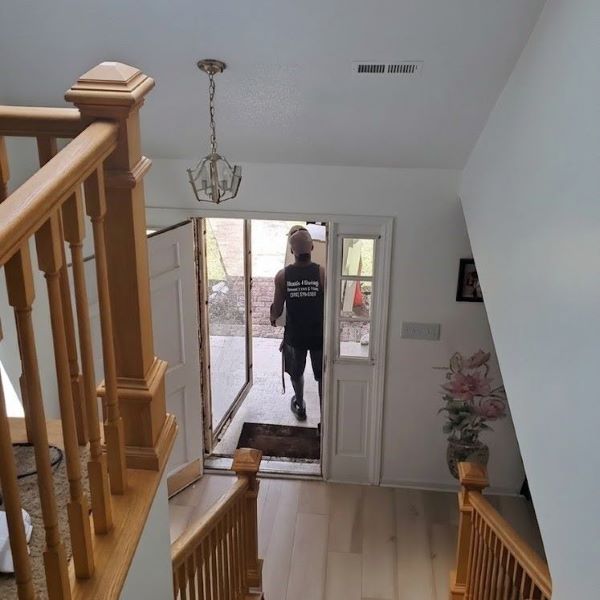 Affordable movers in Harvest, AL from Muscle 4 Moving carrying furniture through the front doorway of a home on Westbury Dr. during a last minute residential move.