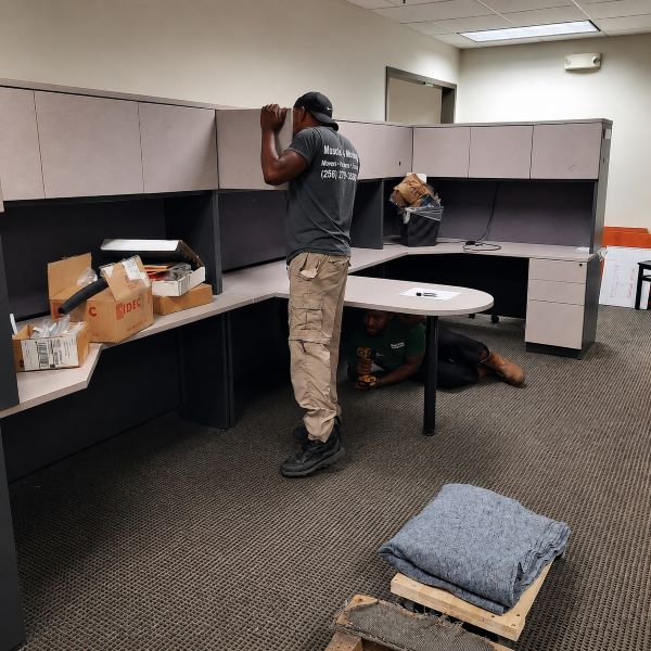 Commercial movers from Muscle 4 Moving providing furniture moving help at The Offices At Spenryn in Madison, AL, as they clean out and disassemble office cubicles for relocation within an office suite.
