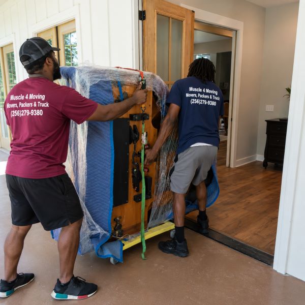 A wrapped baby grand piano being moved into a home at Indian Trace in Athens AL by piano movers from a specialty and heavy item moving company, Muscle 4 Moving.