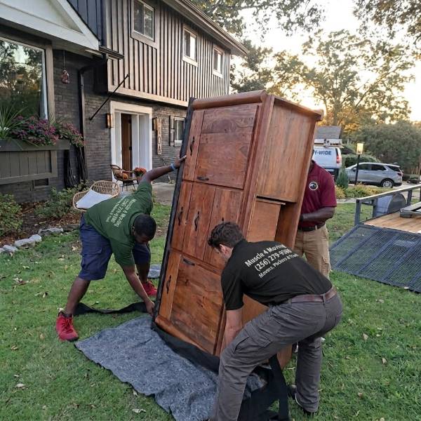 A heavy item moving service utilizing professional moving labor help from Muscle 4 Moving movers to carefully offload and carry a large, heavy item into a home located in the Raleigh Spring subdivision in Ryland, AL.