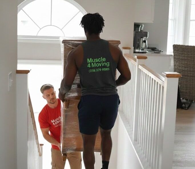 Two Muscle 4 Moving crew members carrying a wrapped piece of furniture down some stairs to load on a truck.